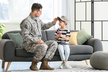 Soldier and his little son with USA flag at home. Memorial Day celebration