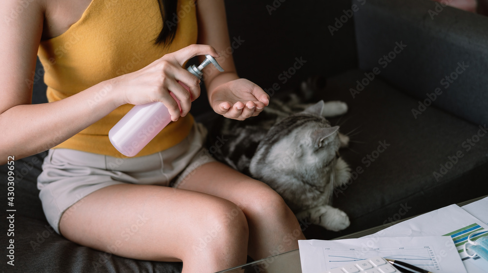 Woman work from home, Washing your hand by alcohol sanitizer gel for protecting infection from a Covid-19 virus and other viruses