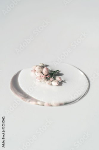 A drop of cosmetic gel with flower on a white background.
