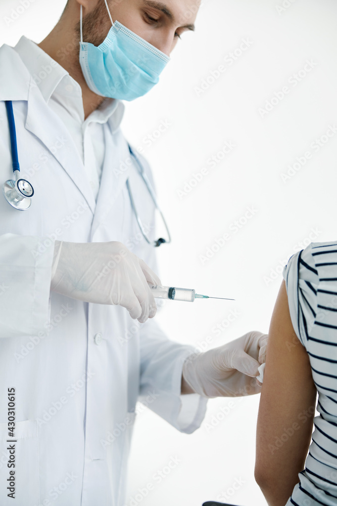 male doctor in a white coat injections in the arm with a vaccine coronavirus male doctor in a white coat injections in the arm with a vaccine coronavirus