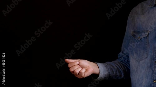 Male isolated on black background tossing coin to make decision concept photo