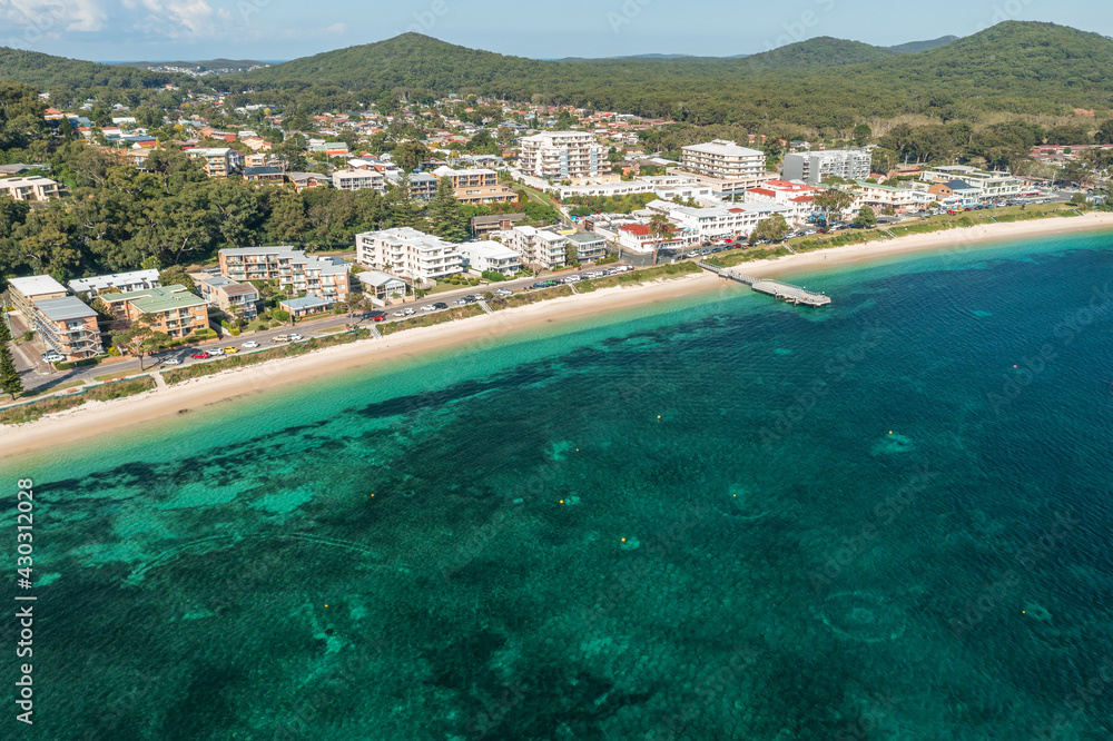 Aerial view of Shoal Bay foreshore, wharf and town, and beautilful aqua waters