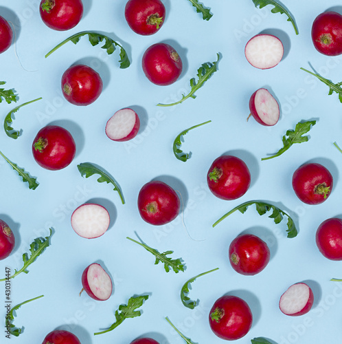 Vegetable seamless pattern of radish and arugula with shadow in hard light on blue background.