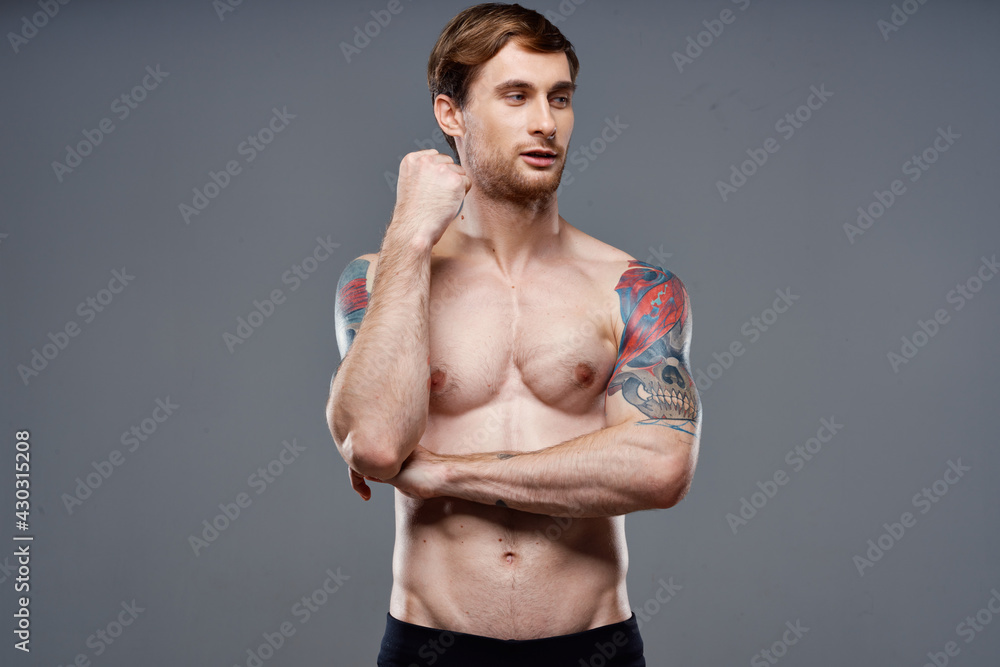 man with tattoos on his arms pumped up torso workout cropped view bodybuilder