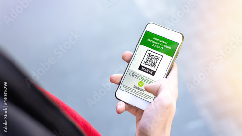 Male hand holding a smartphone with International Vaccination Certificate COVID-19 QR code