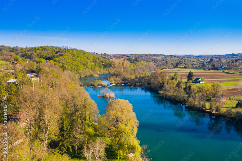Mreznica river in Croatia from air, drone view of Belavici village in spring