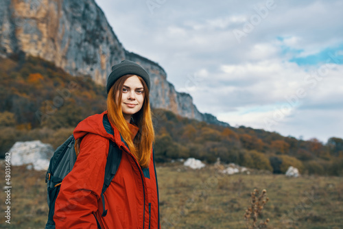 woman travels in the mountains with a backpack on her back landscape autumn warm clothes model