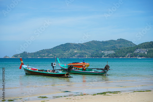 Old Thai wooden boats. Traditional tropical seascape. Traditional wooden longtail taxi boat. Fishing boat docked off the coast of the blue sea.