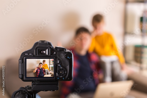 Vlogger family recording social media video while sitting on couch