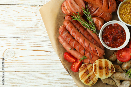 Concept of tasty food with tray of grilled sausage on wooden table