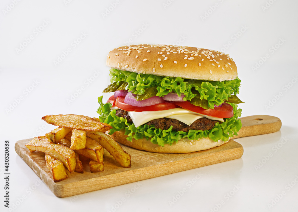 Hamburger, vegetables, beef, onion rings, french fries on a cutting board, white background Hamburger, vegetables, beef, onion rings, french fries on a cutting board, white background