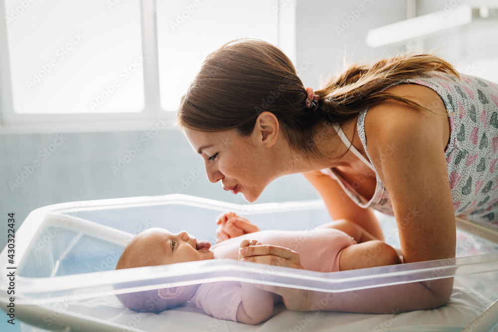 Naklejka premium Mother holding her newborn baby child after labor in a hospital