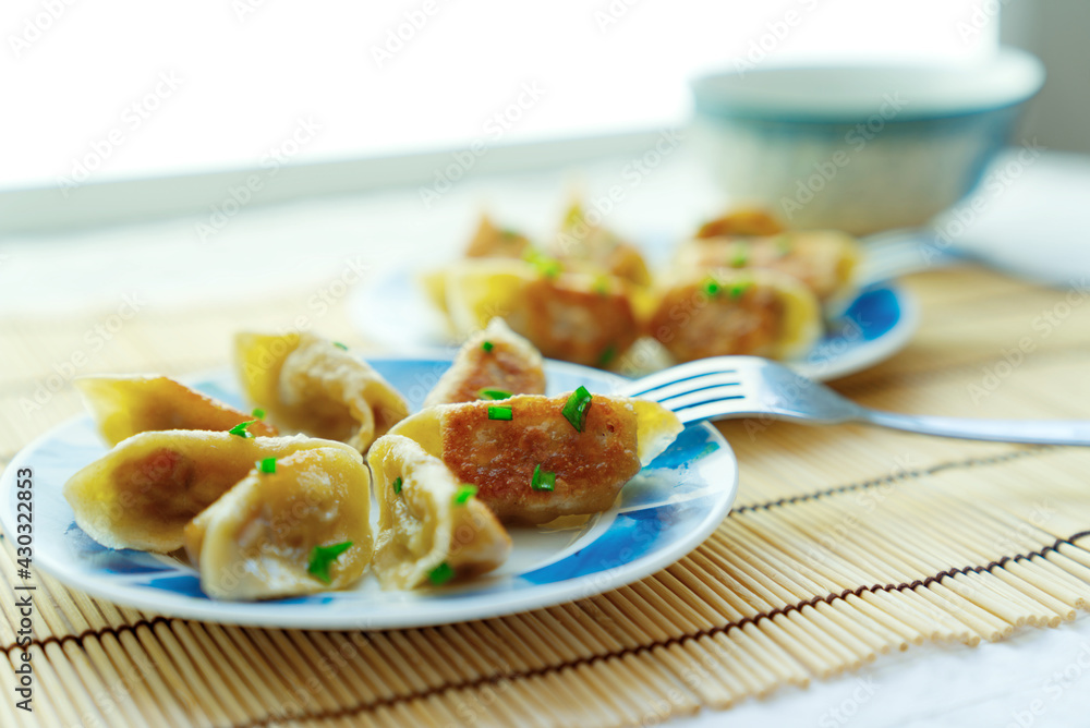 Close-up two plates of golden fried buns with fork in the plate, depth of field picture, traditional Chinese snack