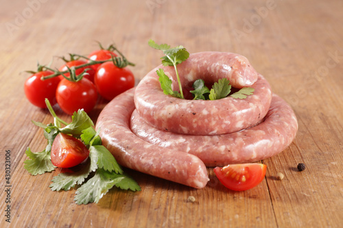 raw sausage and herbs on wood background