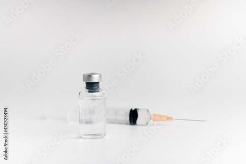 The vaccine vials, syringes and stethoscope are placed together on a white background. COVID-19 virus protection concept, vaccine invention and production concept.