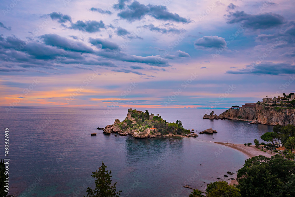 View of Isola Bella Nature Reserve in Taormina, Sicily by sunset. Soft pastel color sky 