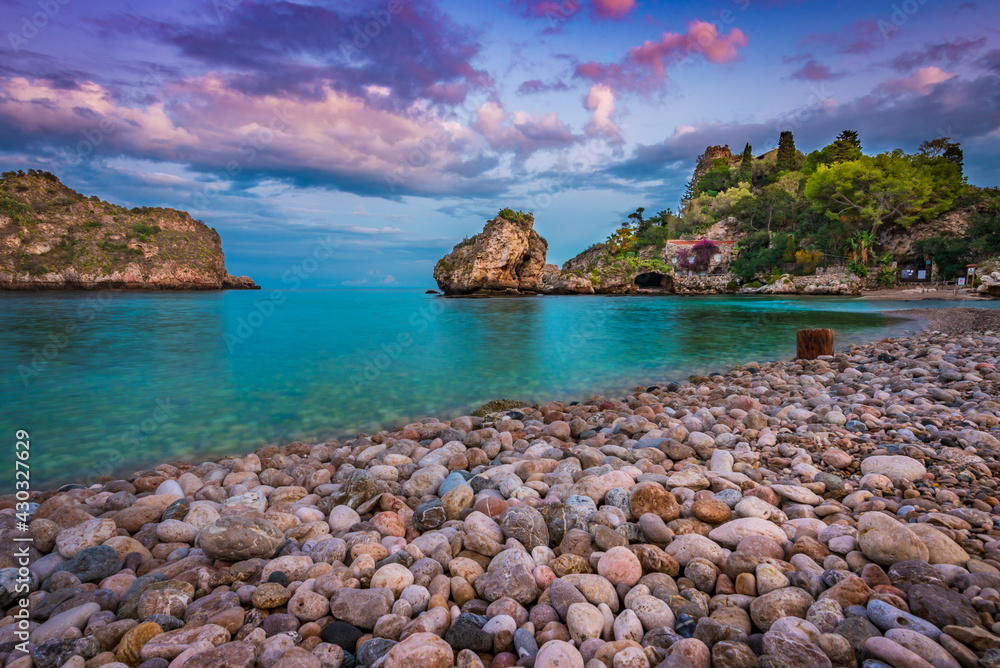Beautiful sunset scenery on the coast of Isola Bella - a small island in Taormina , Sicily 