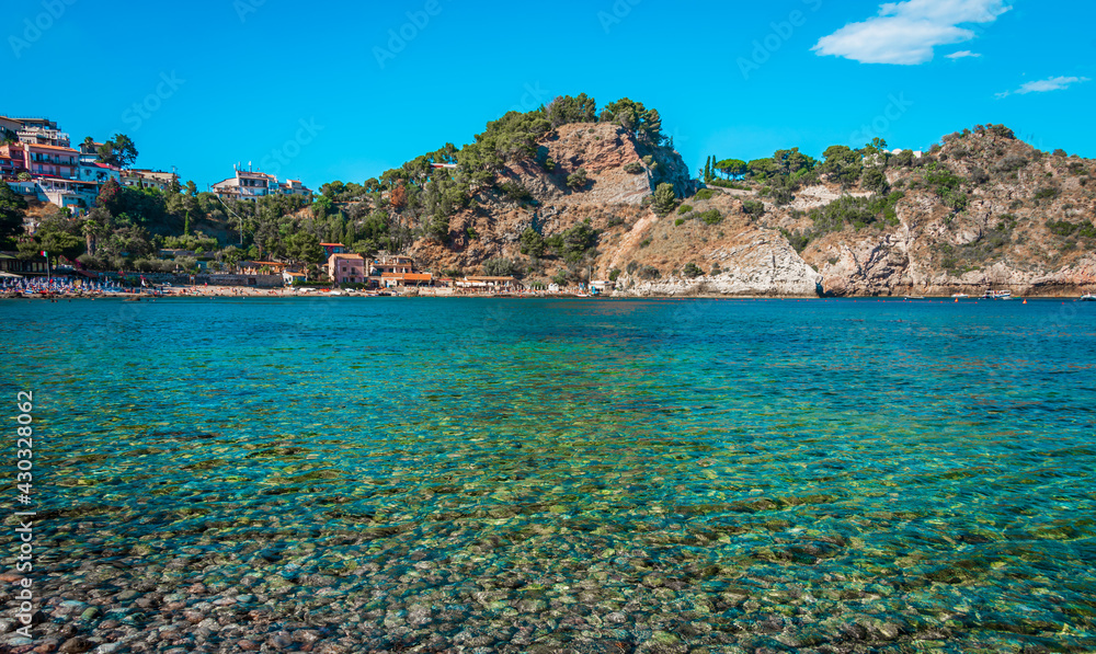 Marvelous sunny beach (Isola Bella) on the coast of Taormina, Sicily. Crystal clear turquoise water on the beach of Isolabella, Taormina