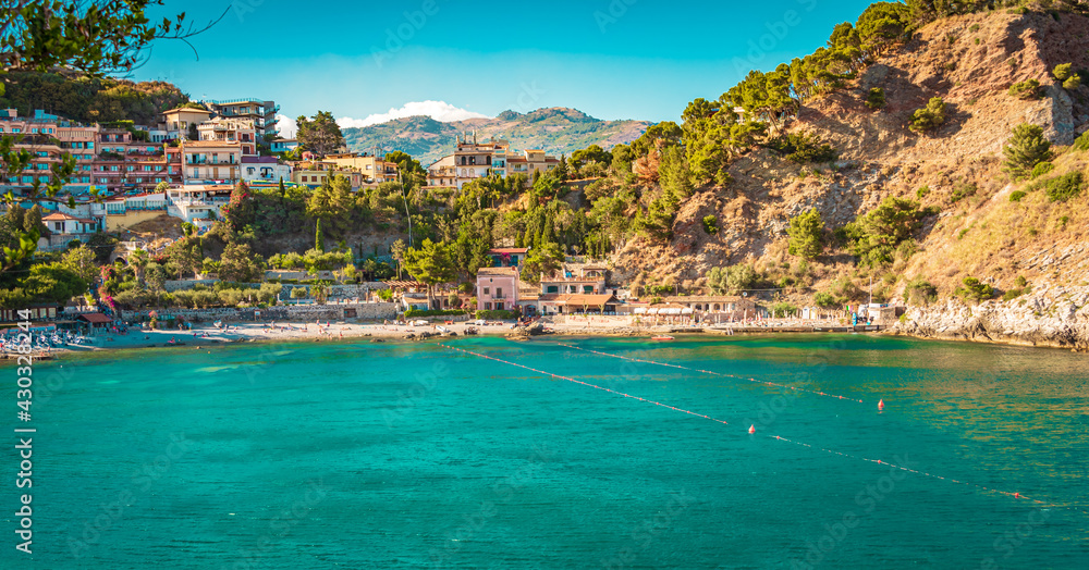 Marvelous sunny beach (Isola Bella) on the coast of Taormina, Sicily. Crystal clear turquoise water on the beach of Isolabella, Taormina