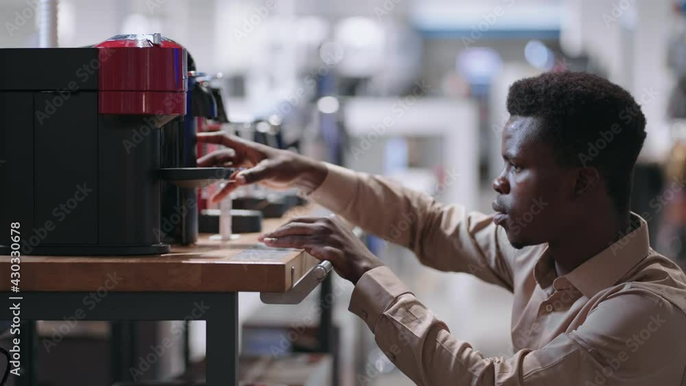 young afro-american man is choosing automatic coffee maker in appliance store, buying modern device young afro-american man is choosing automatic coffee maker in appliance store, buying modern device