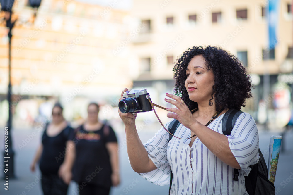 Female freelance photographer. Woman taking pictures in city.