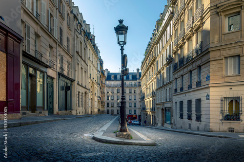 Fototapeta Naklejka Na Ścianę i Meble -  Paris, France - April 26, 2021: A typical cobblestone street in Paris