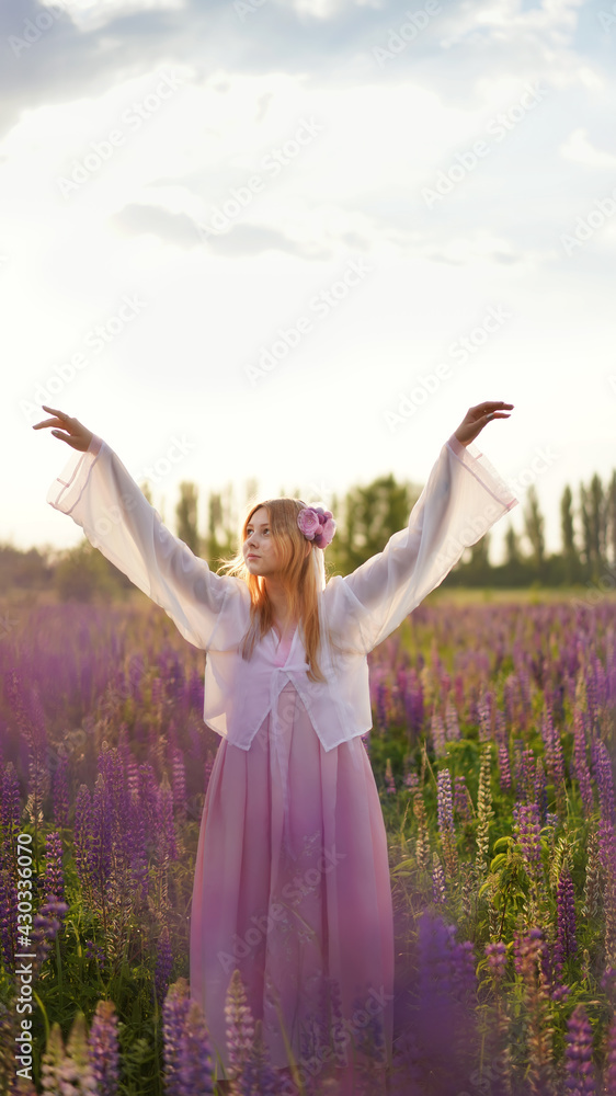 Beautiful blonde girl in a fantasy outfit dress on a field of lupines flowers at sunset in backlight.girl spring hello summer. Magical Photos, Korean Style Clothes. Vertical Beautiful blonde girl in a fantasy outfit dress on a field of lupines flowers at sunset in backlight.girl spring hello summer. Magical Photos, Korean Style Clothes. Vertical