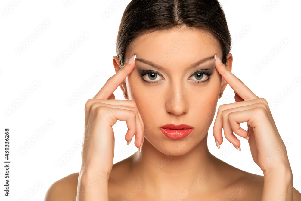 Young woman tightening her face skin with her fingers Young woman tightening her face skin with her fingers
