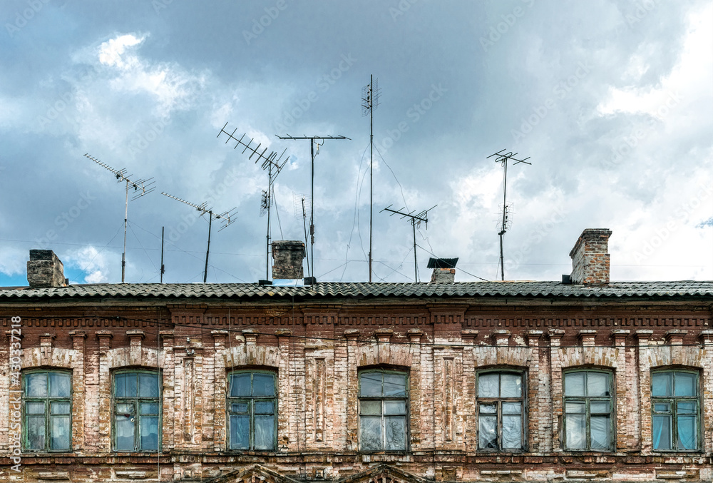 Fototapeta premium Obsolete rusty television antennas on the roof of an old house. Analog technology