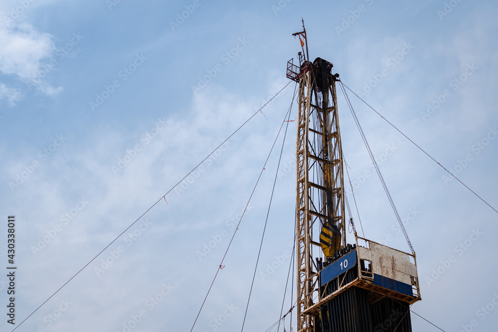 Oil drilling rig derrick platform structure with blue sky background. Heavy industrial operation and energy business photo. Oil drilling rig derrick platform structure with blue sky background. Heavy industrial operation and energy business photo.