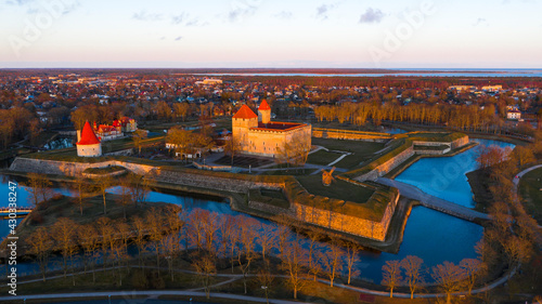 Fotografiet Aerial view to the sunset colored coastal historic medieval fortress with the su