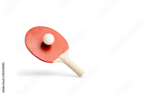 Raqueta de ping-pong con una pelota levitando sobre un fondo blanco liso y aislado. Vista de frente. Copy space. Concepto: Deportes photo