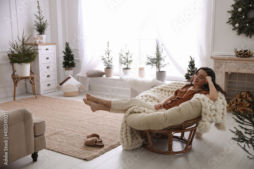 Woman resting in comfortable papasan chair at home photo