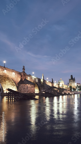 Banner, Charles Bridge in Prague at night. Panoramic image of Vltava riverside with illuminated Charles Bridge, medieval towers reflected in water. Famous travel destination in Czech Republic.