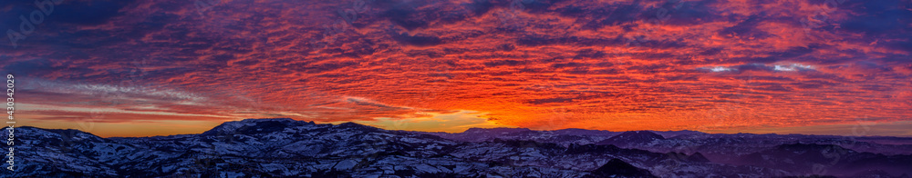 Panorama spettacolare al tramonto, con cielo nuvoloso infuocato dal sole, visto dalla Repubblica di San Marino
