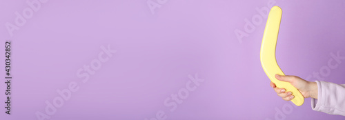 Woman holding boomerang on lilac background, closeup. Space for text