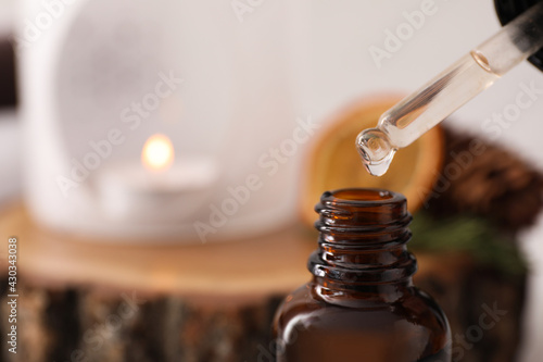 Dripping of coniferous essential oil into bottle, closeup. Space for text photo