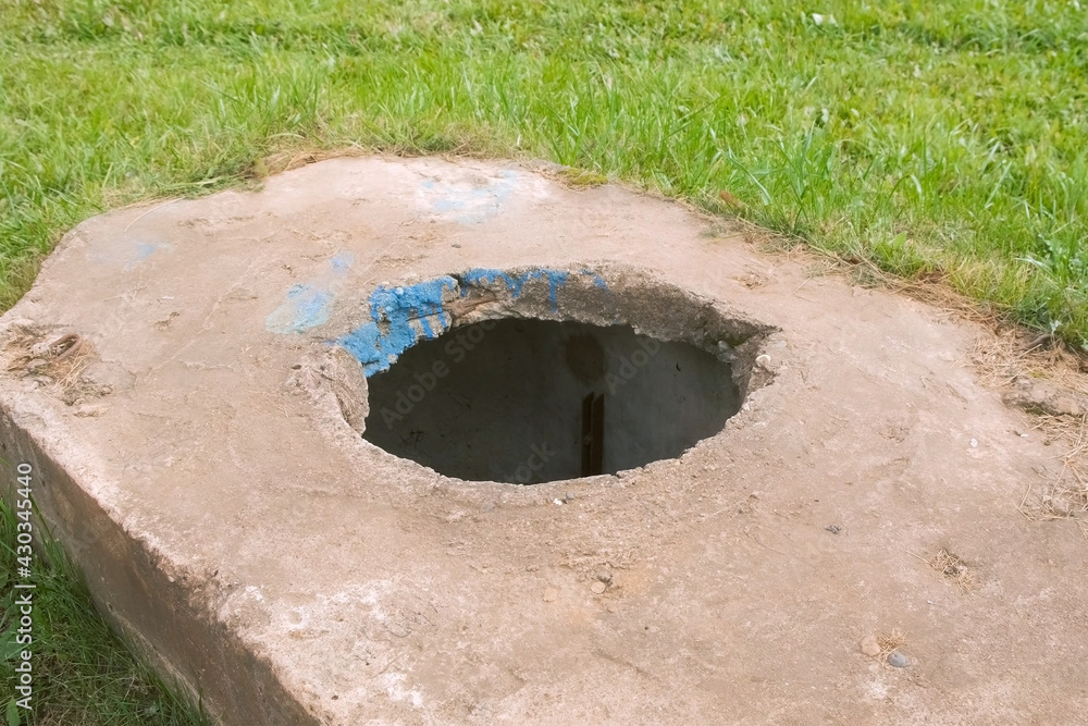 Open manhole in the city near the road, destruction and lack of infrastructure. Park in town, dangerous for walking people and children. Open manhole in the city near the road, destruction and lack of infrastructure. Park in town, dangerous for walking people and children.