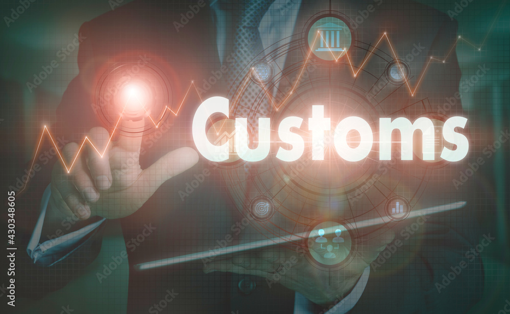 A businessman operating a computer display with a Customs business word concept on it.
