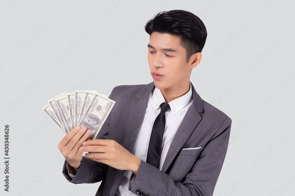 Young asian business man holding money dollar isolated on white background, businessman in suit holding banknote and success and excited with finance, savings and investment, income and spending. Young asian business man holding money dollar isolated on white background, businessman in suit holding banknote and success and excited with finance, savings and investment, income and spending.