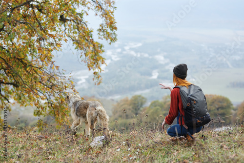 woman outdoors in the mountains next to the dog friendship travel