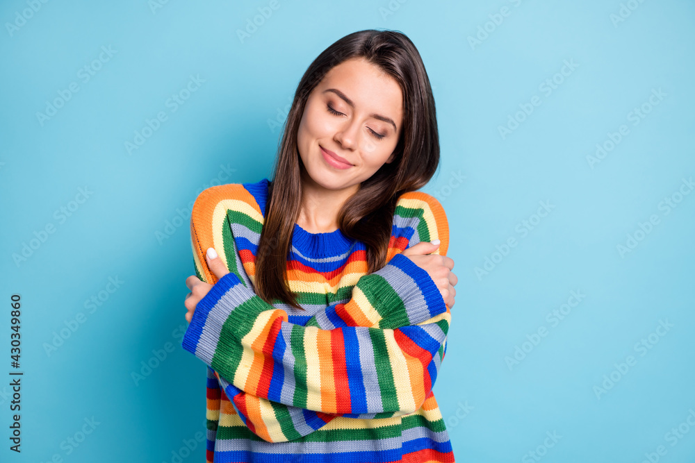 Portrait of attractive dreamy calm cheery brown-haired girl hugging herself isolated over bright blue color background Portrait of attractive dreamy calm cheery brown-haired girl hugging herself isolated over bright blue color background