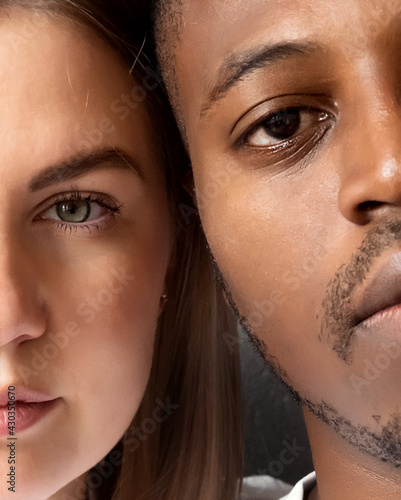 The faces of two people on a gray background. International family