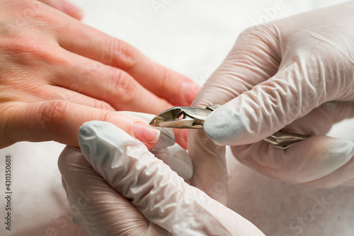 Woman in a nail salon receiving a manicure by a beautician with nail file. Beauty and hand care close-up.