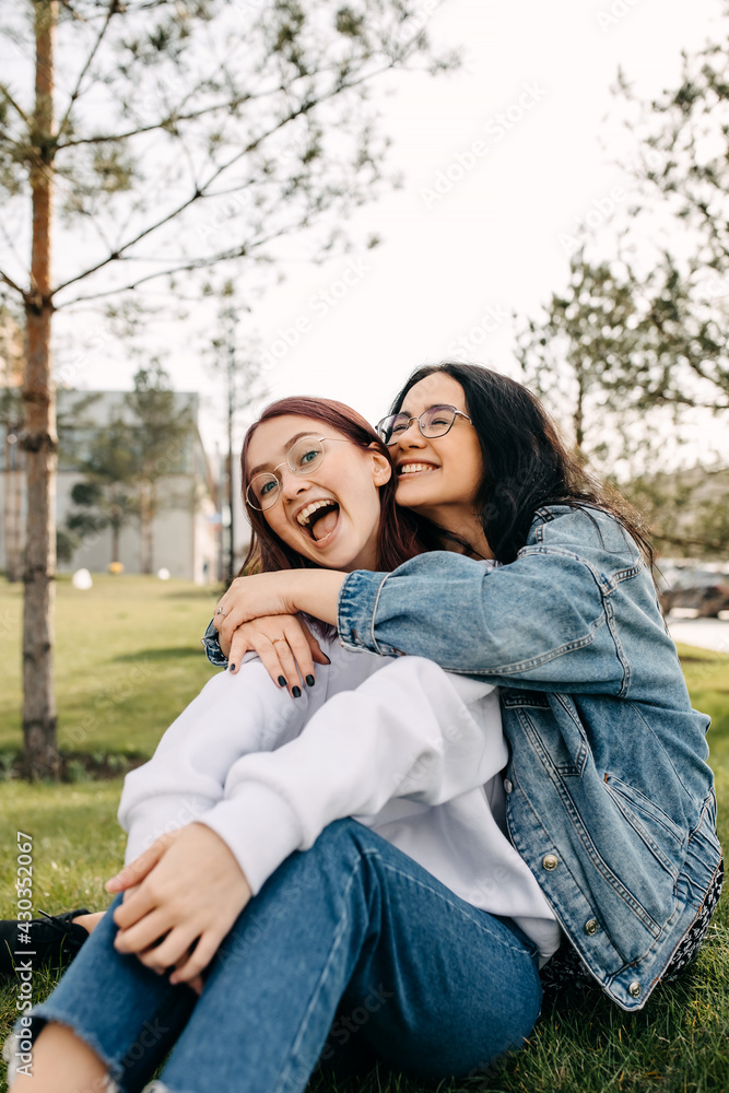 Two sisters smiling, spending time outdoors. Best friends concept. Two sisters smiling, spending time outdoors. Best friends concept.