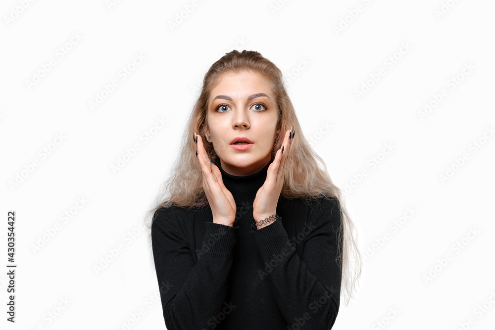 Portrait of shocked young woman holding hands near face, looking concerned and nervous, white background Portrait of shocked young woman holding hands near face, looking concerned and nervous, white background