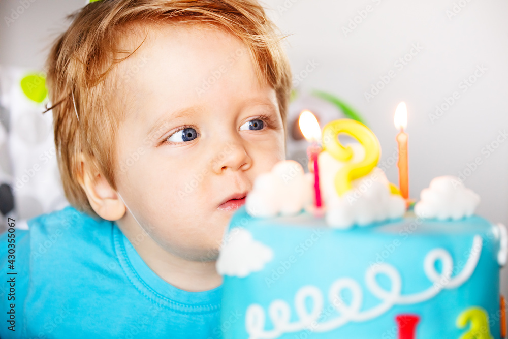 Close portrait of a toddler blow candles on cake Close portrait of a toddler blow candles on cake