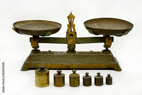 Old vintage balance scales, cast iron with old and rusty weights on white background