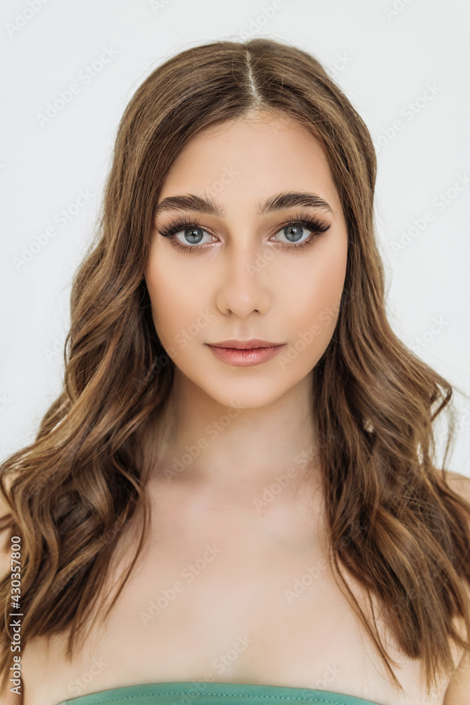 the face of an attractive young woman in close-up. portrait of a Caucasian blue-eyed woman with curls. the concept of youth, skin and hair care the face of an attractive young woman in close-up. portrait of a Caucasian blue-eyed woman with curls. the concept of youth, skin and hair care