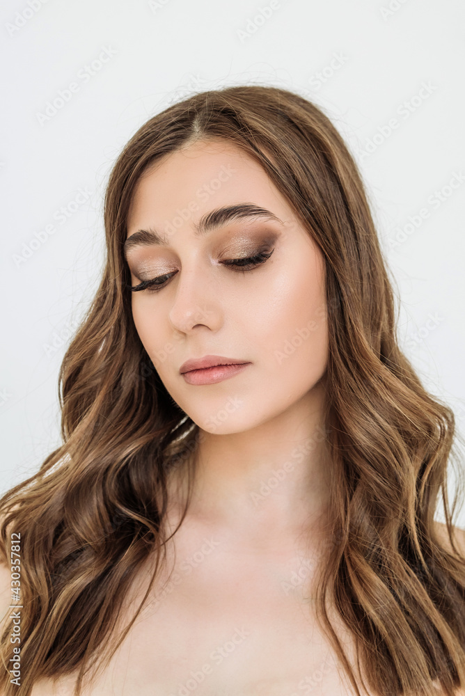 Fototapeta premium the face of an attractive young woman in close-up. portrait of a Caucasian blue-eyed woman with curls. the concept of youth, skin and hair care